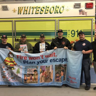 WFD members holding banner in front of truck